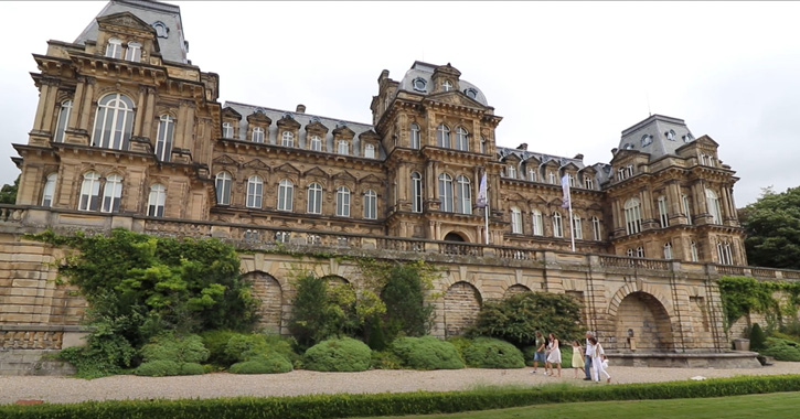 family walking in the grounds of The Bowes Museum, with gran museum building in background.